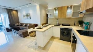 a kitchen and living room with a washing machine in it at Les Jardins Bleus Pool - Martil in Martil