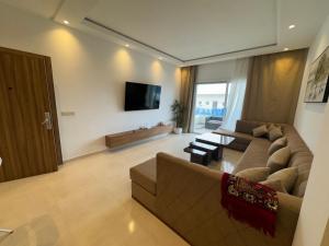 a living room with a couch and a flat screen tv at Les Jardins Bleus Pool - Martil in Martil +24 photos