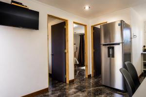 a kitchen with a stainless steel refrigerator in a room at Cabaña bosquepaz in Algarrobo