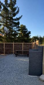 a park bench sitting next to a wooden fence at Cabaña bosquepaz in Algarrobo +3 photos
