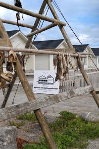 a sign on a wooden gate in front of a house at Værøy Brygge Hotell in Værøy