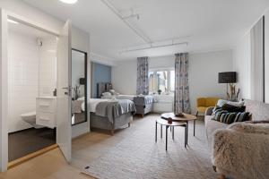 a living room with a couch and a bedroom at Værøy Brygge Hotell in Værøy