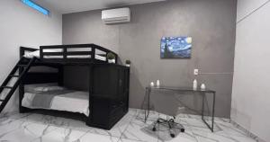 a bedroom with a bunk bed and a desk at reforma tecoman colima mexico in Tecomán