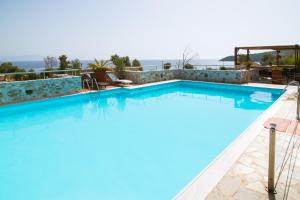 a large swimming pool with a view of the ocean at Vathi Hotel in Vathi
