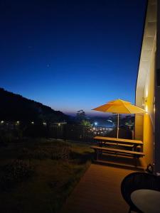 a picnic table with an umbrella at night at Paju Espacio Brillante in Paju
