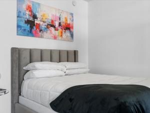 a bedroom with a bed with a painting on the wall at 29th Floor Balcony Studio Miami Skyline Views in Miami +23 photos