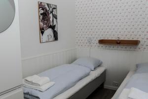 a small room with two beds and a cross on the wall at BLÅBJERGGAARD - Hennebysvej 60 in Henne Strand