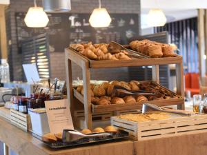 a bakery counter with various types of bread and pastries at hotelF1 Laval in Changé +49 photos