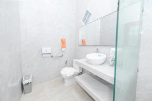 a white bathroom with a sink and a toilet at Dewandaru Homestay 2 in Tonogoro