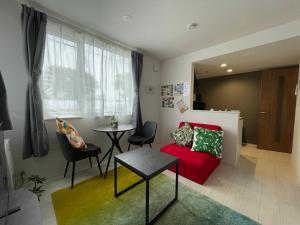 a living room with a red couch and a table at イーエフ千歳駅 in Chitose