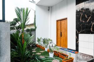 a courtyard with plants and a wooden door at Dewandaru Homestay 2 in Tonogoro