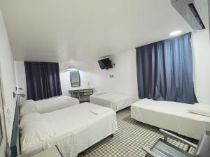 ein Krankenzimmer mit zwei Betten und einem Fernseher in der Unterkunft HOTEL OLIDEN in Coatzacoalcos