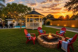 a group of chairs around a fire pit with a gazebo at Tropical Dream - Pool - Firepit - Gazebo in Largo