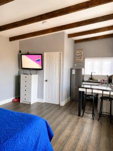 a room with a bed and a kitchen with a tv at Cabaña bosquepaz in Algarrobo