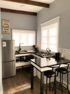a kitchen with a stainless steel refrigerator and a table at Cabaña bosquepaz in Algarrobo