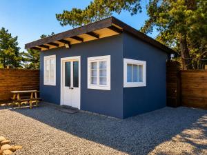 a blue shed with a wooden fence at Cabaña bosquepaz in Algarrobo