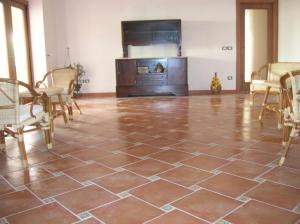 um quarto com piso em azulejo, mesa e cadeiras em Casa mia em Calatabiano