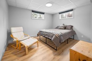 a bedroom with a bed and a chair at La perle bleu in Rivière-à-Pierre