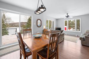 a dining room with a wooden table and chairs at La perle bleu in Rivière-à-Pierre +9 photos