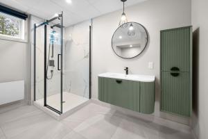 a bathroom with a sink and a shower and a mirror at La perle bleu in Rivière-à-Pierre