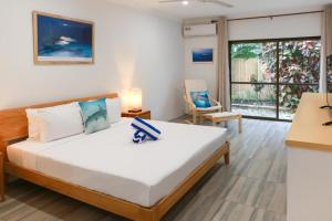 a bedroom with a large bed and a window at Birch Resort Port Douglas in Port Douglas +20 photos