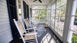 a porch with chairs and windows on a house at Victorian On North in Cape May