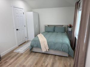 a bedroom with a bed with a green comforter at Modern Private Studio - Separate Entry in Edgewood
