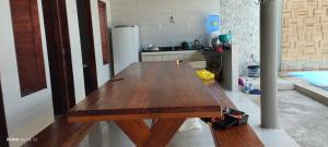a large wooden table in a kitchen with a counter at beach house in Pontal de Coruripe in Coruripe