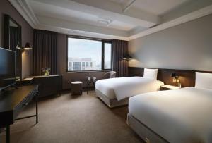 a hotel room with two beds and a television at Maison Glad Jeju in Jeju +167 photos