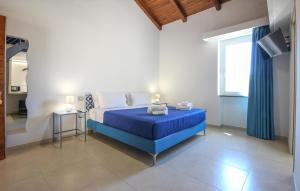 a bedroom with a blue bed and a window at L'antica Pietra in Perdifumo