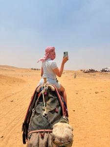 a woman riding on the back of an elephant in the desert at Lava pyramids hotel in Cairo