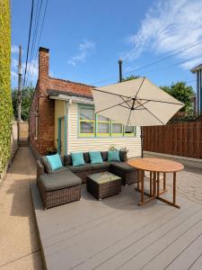 a patio with a couch and a table and an umbrella at Logan Square Coach House in Chicago