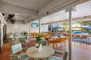 a restaurant with tables and chairs and a car outside at Hotel Allen in Townsville