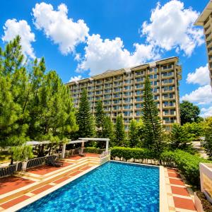 a swimming pool in front of a large building at Cityscape Suite in Davao City