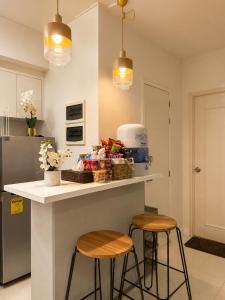 a kitchen with two stools and a counter with food on it at Cityscape Suite in Davao City