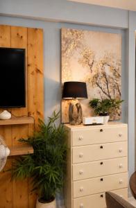a dresser with a television and a painting on the wall at Cityscape Suite in Davao City