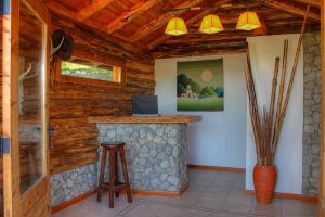 a bar in a log cabin with a laptop at Paraiso de Montaña in Villa Pehuenia