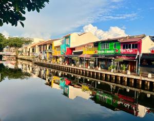a group of colorful buildings next to a river at JonkeRED Heritage Hotel in Malacca