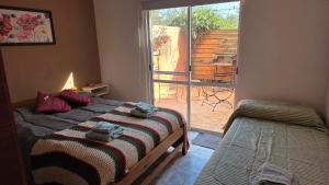 a bedroom with a bed and a sliding glass door at CASA VERDE 1 depto in Carhué