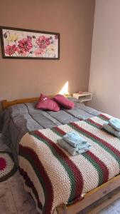 a bed with a colorful blanket and pillows on it at CASA VERDE 1 depto in Carhué