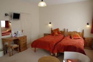 a bedroom with a bed and a desk and a television at The Reading Rooms in Haydon Bridge