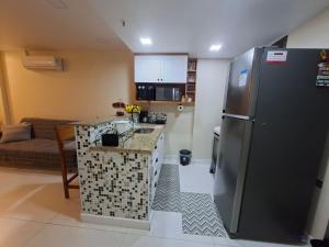 a kitchen with a stainless steel refrigerator and a counter at Apartamento completo Premium-Frente ao Mar Wi-Fi rápido-ar-condicionado in Rio de Janeiro