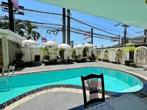 a swimming pool with a chair in front of a building at Orchid Hotel and Spa Kalim Bay in Patong Beach +11 photos