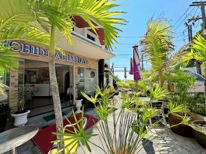 a restaurant with palm trees in front of it at Orchid Hotel and Spa Kalim Bay in Patong Beach