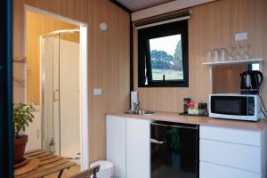 a small kitchen with a microwave and a sink at Bayview Paradise by Tiny Away in Diamond Harbour +20 photos