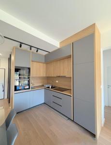 a kitchen with white cabinets and a large sliding glass door at Luxury 2BR Sea View & Garage & Twin Towers Becici in Bečići