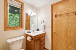 a bathroom with a toilet and a sink and a mirror at Up North Chalet Ac Bbq Bikes in Cedar +110 photos