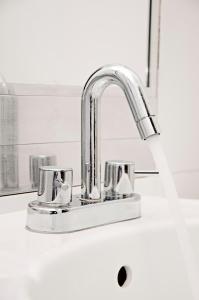 a kitchen sink with a chrome kitchen faucet at Flamante Hotel & Suite in Lima