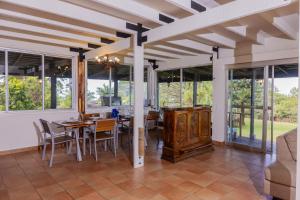 a dining room with a table and chairs and windows at La Dama de los vientos in Cerro Azul
