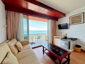 a living room with a couch and a view of the ocean at Orchid Hotel and Spa Kalim Bay in Patong Beach